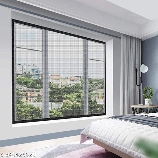 Slim black-frame magnetic insect mesh screen fitted over a large multi-pane bedroom window overlooking outdoor trees and neighborhood rooftops.